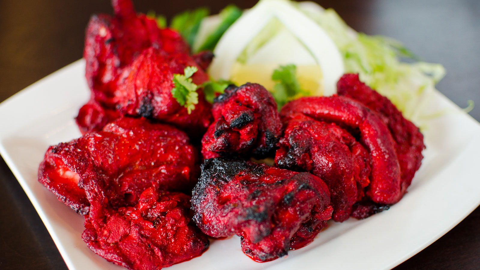 Tandoori-grilled chicken tikka, freshly charred and garnished