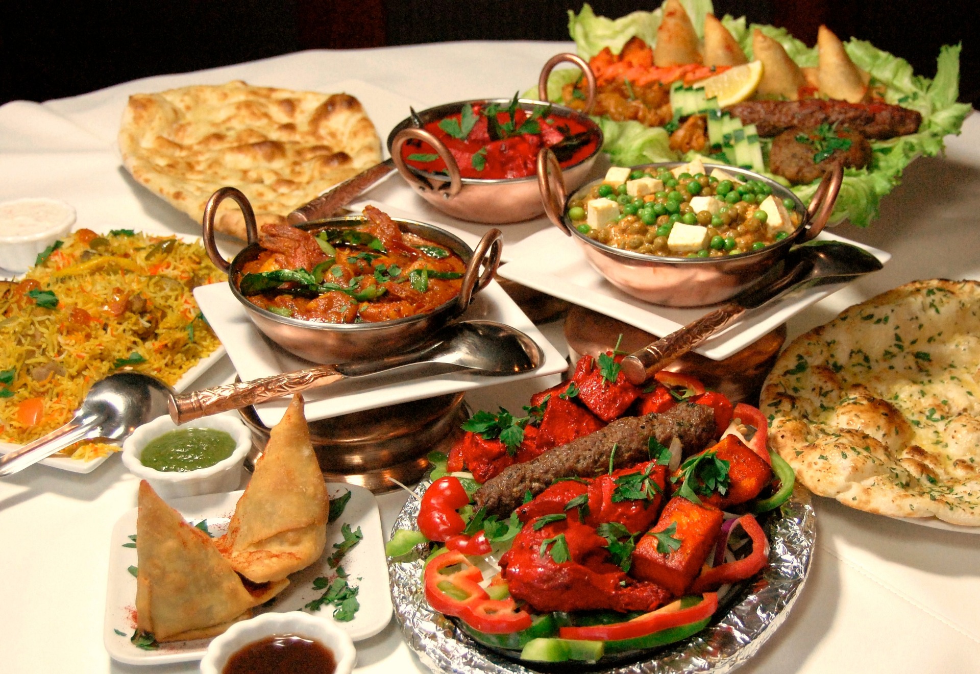 A spread of RANA's Pakistani dishes — karahi curries, biryani, tandoori grill and fresh naan